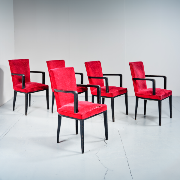 Suite cinq fauteuils Jacques Adnet bois laqué noir garniture tissu rouge vers 1960