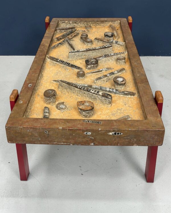 Table basse en pierre fossilifère à orthocères, bois patiné et laqué rouge, 2020, vue 2